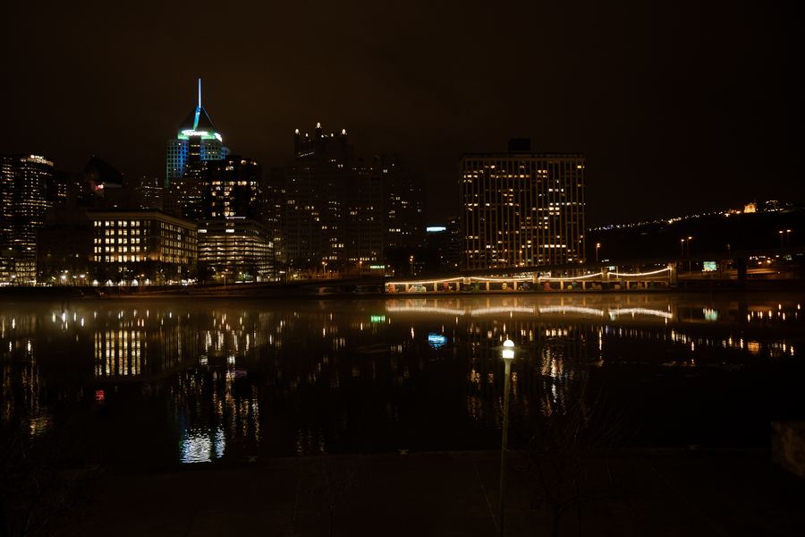 Downtown Pittsburgh's lights reflected in the river at night.